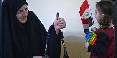 An Iraqi voter shows her ink-marked thumb to her family members after casting her ballot at a polling station in the southern city of Basra on November 11, 2025 during Iraq's parliamentary elections. Photo: AFP