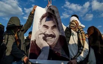 Youngsters hold a photograph of Abdullah Ocalan as they gather to watch live on a tv screen a Pro-Kurdish Peoples' Equality and Democracy Party, or DEM, delegation members releasing an statement from Ocalan, in Diyarbakir, Turkey. AP file photo