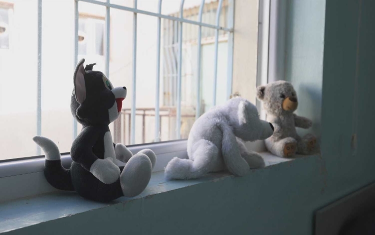 Stuffed toys sit by a window inside an orphanage in Sulaimani. Photo: Screengrab/Rudaw