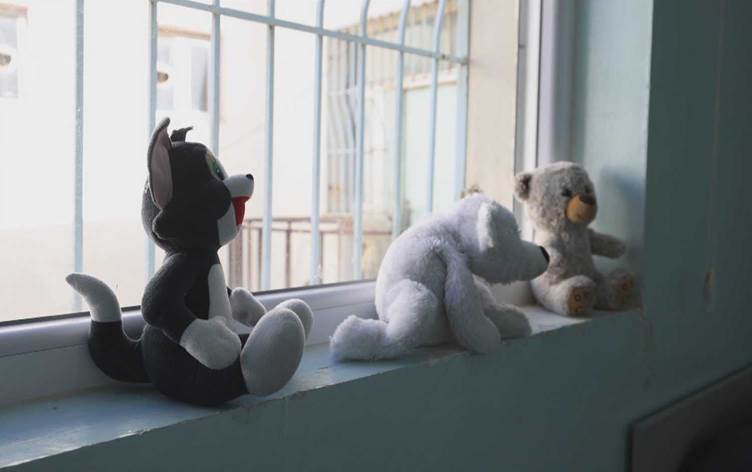 Stuffed toys sit by a window inside an orphanage in Sulaimani. Photo: Screengrab/Rudaw